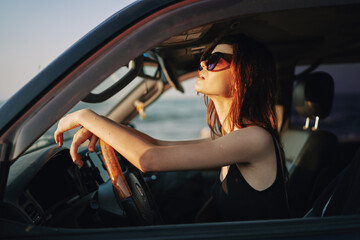 Naklejka na ściany i meble pretty woman in sunglasses driving a car trip