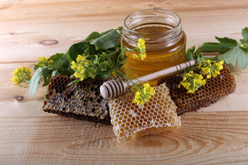 Honey and flowers on table