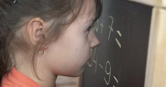 Child stay by blackboard on lesson. A child stay by the chackboard at lesson maths.