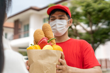 Deliveryman send bags of food to customers in front of the home during the epidemic of Covid-19....