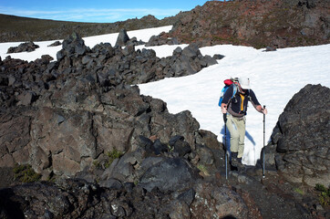 Trekking Villarrica traverse hiking trail, Solidified lava field with snow in Villarrica national...