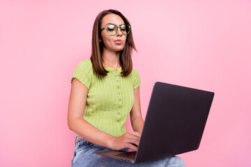 Photo of sad brunette millennial lady write laptop wear green t-shirt eyewear isolated on pink...