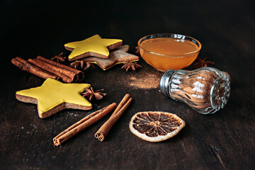 Christmas gingerbread in the shape of stars, spices and honey on a wooden table.