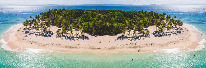 Tropical island on the background of the ocean. Many tourists relaxing. Drone