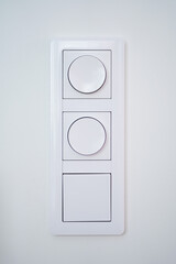 Triple light switch with dimmer on white wall