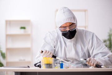 Young male chemist working at the lab during pandemic