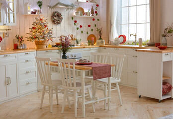 Interior of a light white ?hristmas kitchen with red decor elements in the Scandinavian style. Christmas decorations. Breakfast