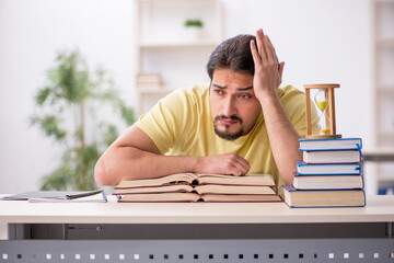 Obraz premium Young male student preparing for exams in time management concep