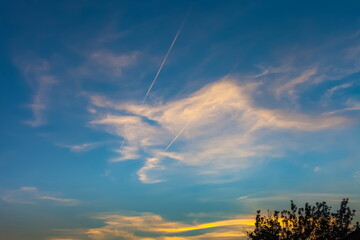 Evening sky with clouds in the rays of the setting sun