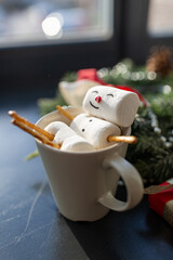 christmas, winter holidays and leisure concept - close up of marshmallow snowman taking bath in cup...