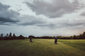 Golfers walking down the golf course on a cloudy day