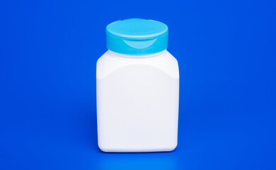 food supplement jar white color on blue background, vitamin