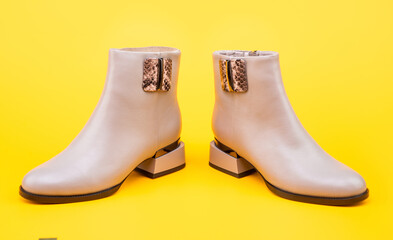 fashionable leather boots on yellow background, footwear