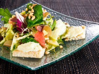 vegetarian salad with fresh green fresh lettuce, grapefruit, sweet pear, nuts and fried bread...
