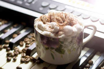 A cup of coffee on the piano keys