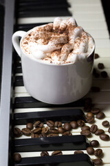 A cup of coffee on the piano keys