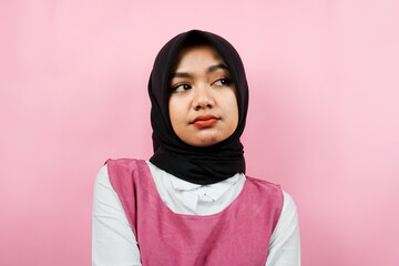 Closeup of beautiful cheerful young Muslim woman, looking at empty space, presenting something, isolated