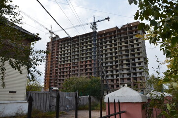 A building under construction with two cranes