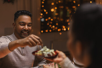 holidays, party and celebration concept - happy man having christmas dinner with friends at home