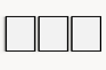 Set of three black portrait picture frame mockups on white wall