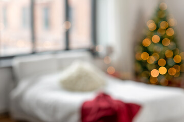 winter holidays, backgrounds and interior concept - blur image of bed in bedroom at cozy home on...