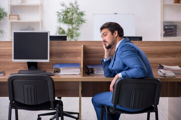 Young male employee sitting at workplace