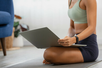 Naklejka premium Asian woman relaxes in home. You start studying yoga in the morning by turning on the computer and joining the class.