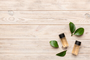 Organic cosmetic products with green leaves on wooden background. Copy space, flat lay
