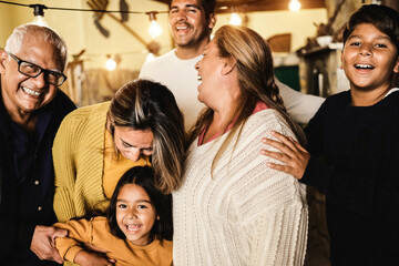 Portrait of happy latin family smiling on camera at home - Focus on grandfather face