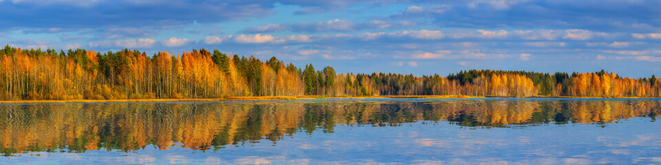 Large-format autumn panorama with a forest and a smooth lake