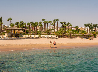 Hurghada, Egypt - September 22, 2021: People stand on the shores of the sandy beach of the Red Sea...