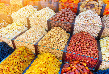Counter with dried fruits and nuts in the oriental bazaar. Variety of natural organic sweets and...