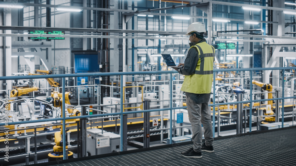 Poster car factory engineer in high visibility vest using laptop computer. automotive industrial manufactur