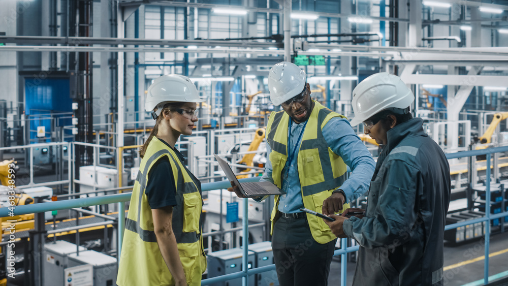 Aufkleber Young Diverse Team of Car Factory Engineers in High Visibility Vests Using Laptop Computer. Automotive Industrial Manufacturing Facility Working on Vehicle Production. Diversity on Assembly Plant.