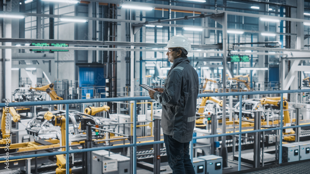 Poster car factory engineer in work uniform using tablet computer. automotive industrial manufacturing faci