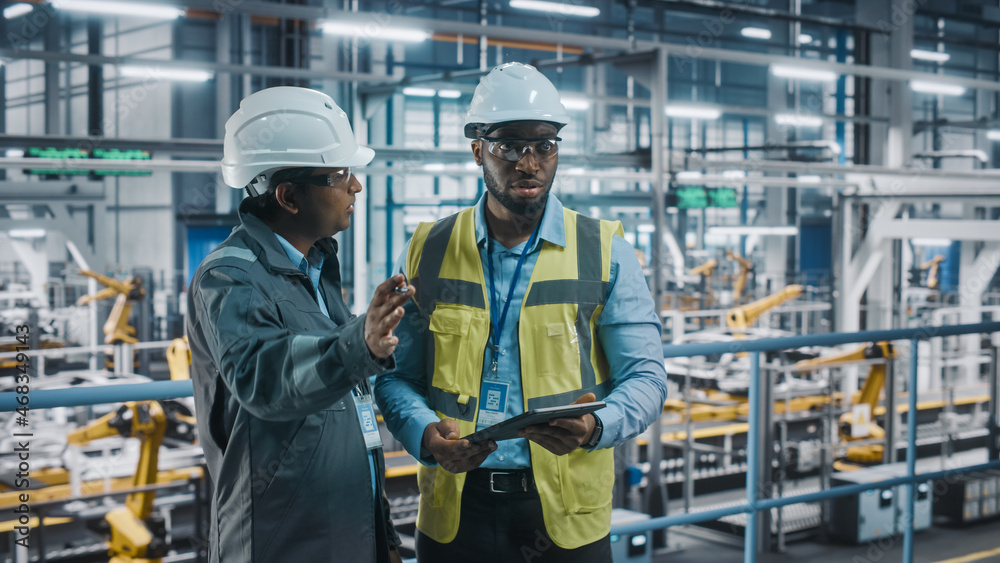 Aufkleber Multiethnic Manager and African American Car Factory Engineer in Uniform Using Tablet Computer. Automotive Industry 4.0 Manufacture Employees Discuss Work on Vehicle Assembly Plant.