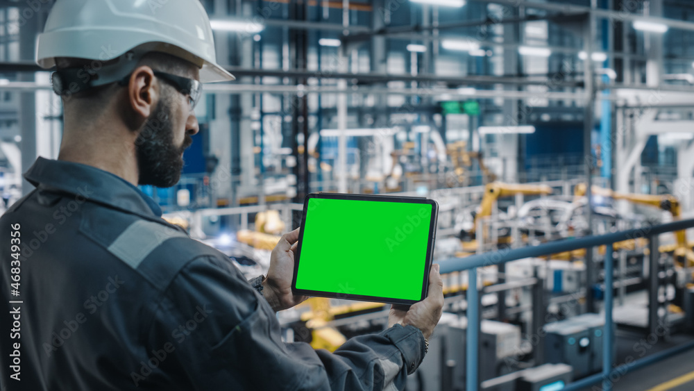 Aufkleber Car Factory Engineer in Work Uniform Using Tablet Computer with Green Screen Mockup Display. Augmented Reality Software at Automotive Industrial Manufacturing Facility Working on Vehicle Production.