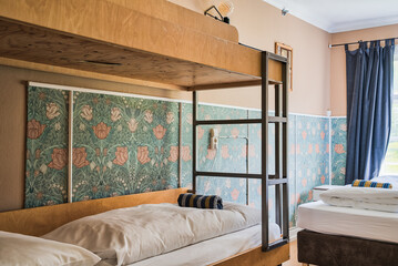 Cosy and quiet room with bunk beds and walls covered with warm colours and ecological environment and recycled materials.Family room. Shared hostel room. Nordic atmosphere and decoration.