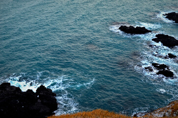 cliff edge and black basalt rocks in the blue sea , Lóndrangar, Iceland