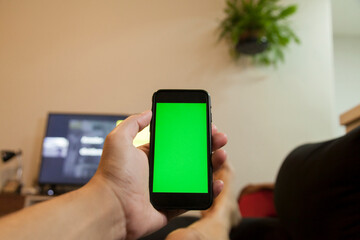 Man holding smartphone in hand indoors in living room. Technology at home. Entertainment concept. Smartphone concept.