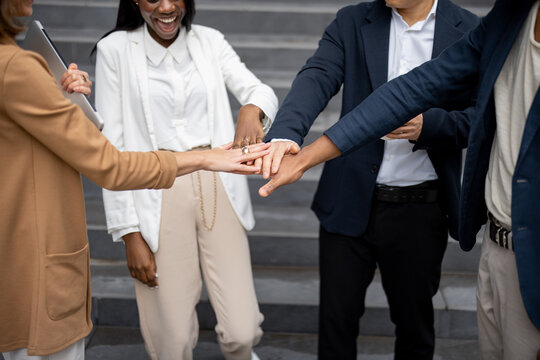 Cropped image of businessteam bumping fists each other on city street. Concept of modern successful business people. Idea of business cooperation. Remote and freelance work. Close up view