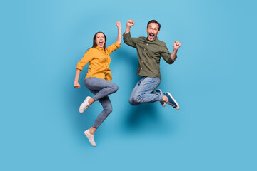 Full body photo of brunette haired husband wife jump up winner good mood isolated on pastel blue...