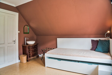 Cosy and quiet room with walls covered with warm colours and ecological atmosphere with recycled objects and furniture. Family room. Shared hostel room. Nordic atmosphere and decoration. Natural light