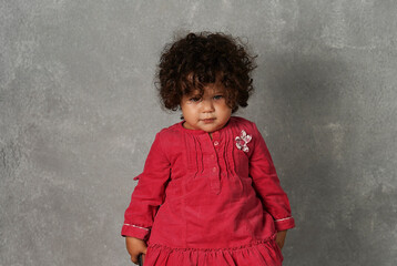 Portrait of a baby girl in a red dress.