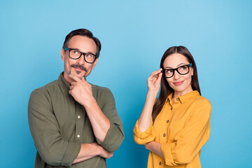 Photo of minded pretty lady handsome man look interested empty space isolated on blue color background