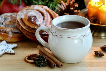Obraz na płótnie Canvas A ceramic mug with tea among traditional Christmas decorations.