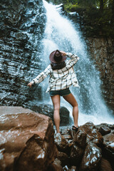 woman in brown hat enjoying view of waterfall