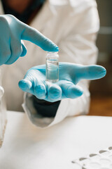 CBD hemp oil, Scientist holding bottle of Cannabis oil against Marijuana plant. Herbal Treatment, Alternative Medicine