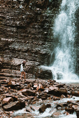 woman traveler enjoying view of waterfall