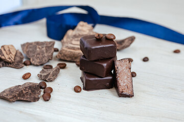  Dark chocolate candys with nuts, cacao and cream on wooden background.